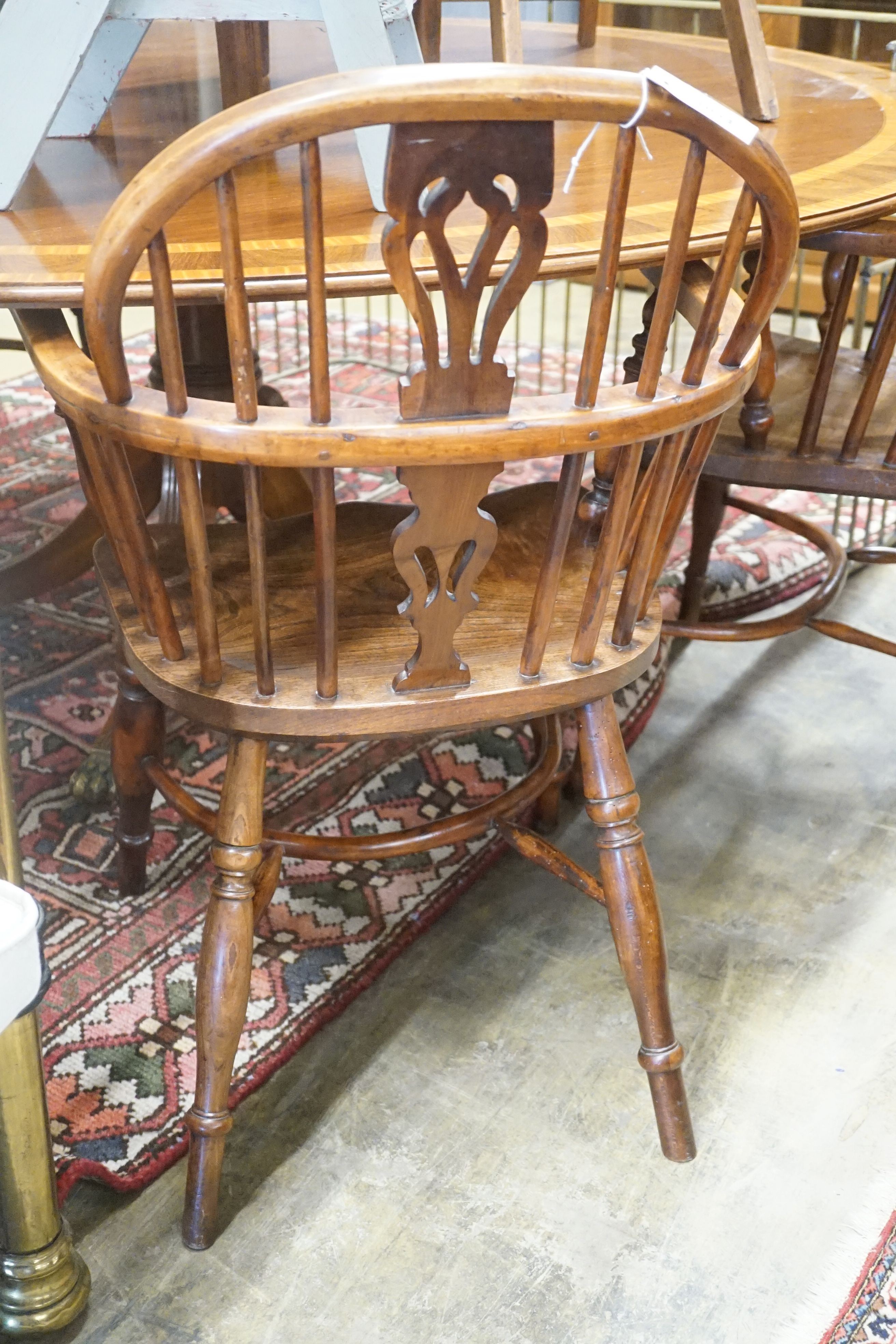 A near pair of mid 19th century Nottingham Area yew and elm Windsor elbow chairs with crinoline stretchers